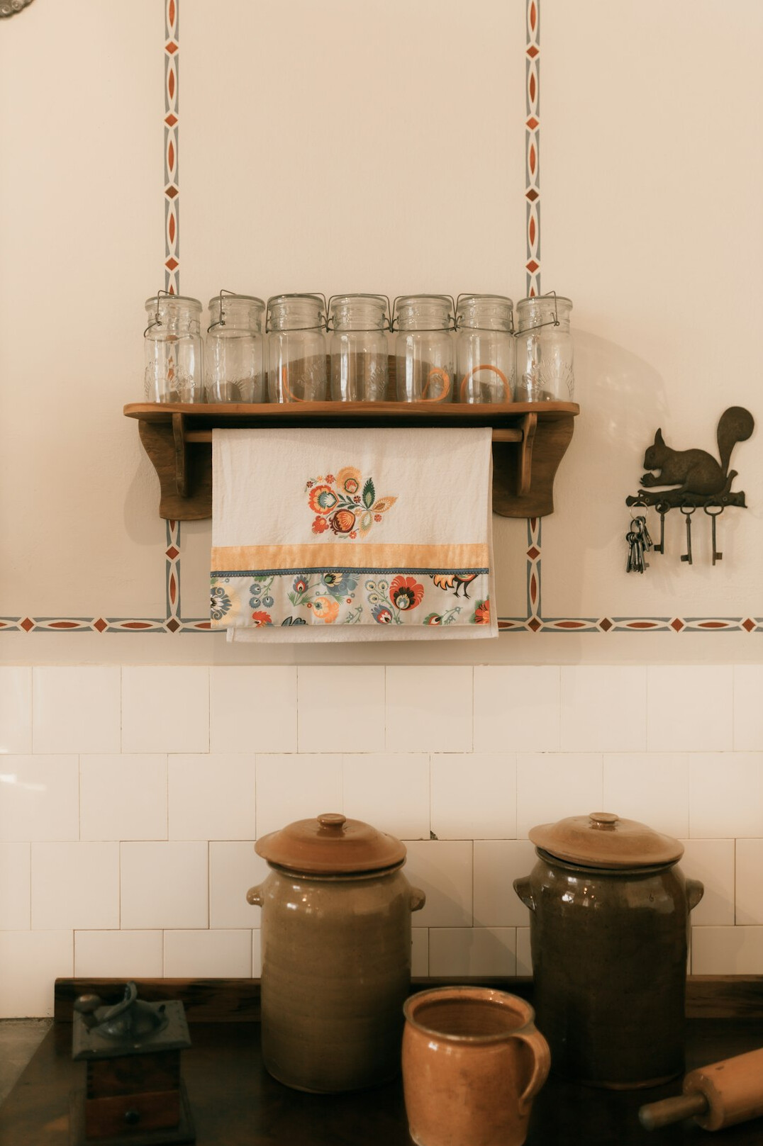 Organized kitchen counter with labeled glass jars and utensils in holders